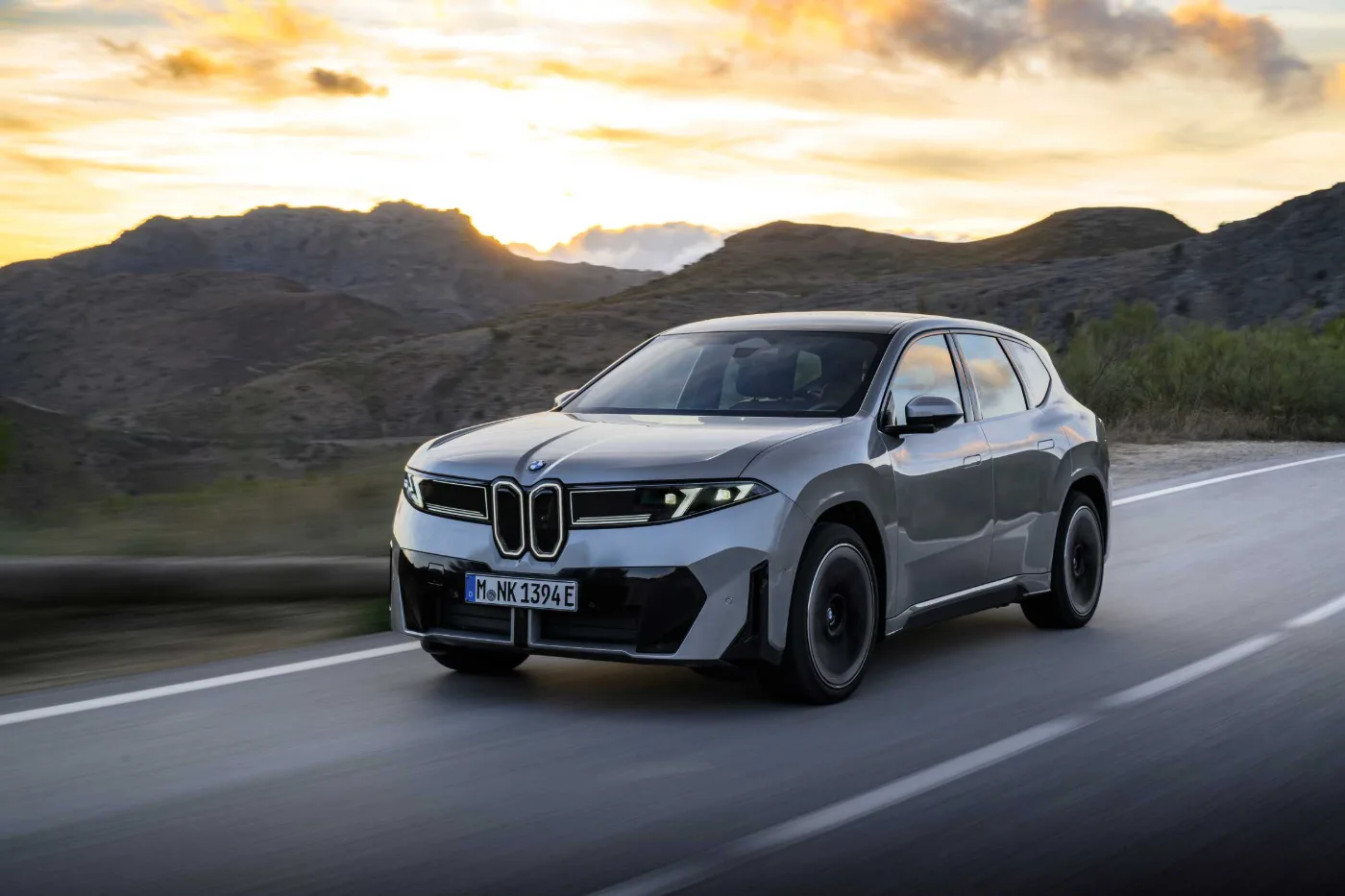 BMW iX3 Space Silver, in Fahrt auf einer Bergstraße