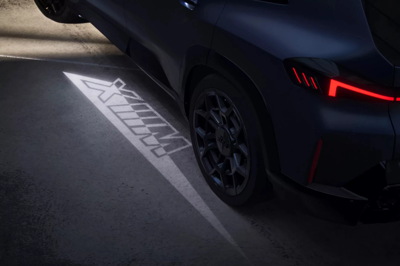BMW XM v noci s uvítacím svetelným kobercom